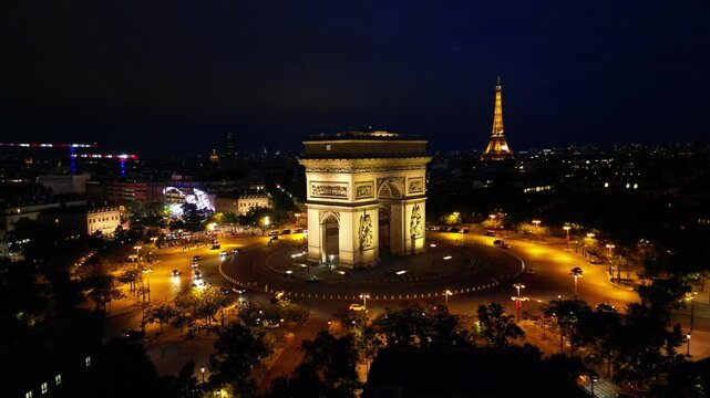 Paris, Arc de Triomphe Triumphal Arch at Chaps Elysees at night, Paris, France. Drone view, Eiffel Tower in the background.  Architecture and landmarks of Paris. Postcard of Paris
