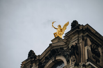 Obraz premium Banner with old golden statue at the dome top in downtown of Dresden, Germany, with copy space 