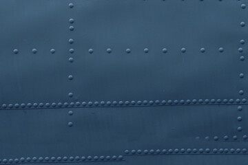 Photo of a metal surface with rivets.