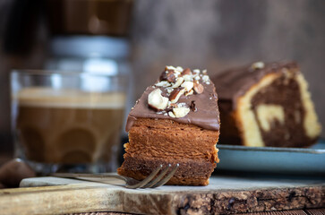 Porción de bizcocho con cobertura de chocolate y avellanas
