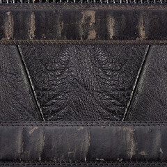 Seamless 4k photo texture photo of black colored worn and weathered leather material with stitched pattern.