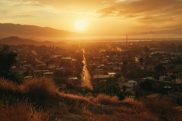 Naklejka premium Stunning sunset over city, golden light illuminates streets and mountains beyond.