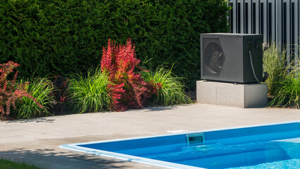 Outdoor heat pump near a swimming pool with surrounding decorative plants.