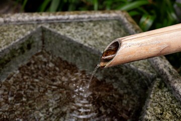 Deer-frightening ‘called Shishi-odoshi’ and water basin in a Japanese garden.