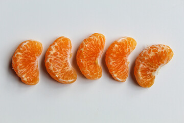 Some orange fruit segments, isolated on white background, flat lay or top view