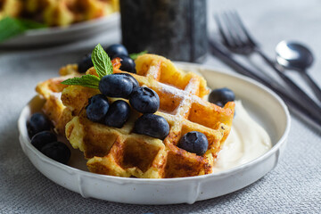 Belgian waffles with sour cream and blueberries in a plate