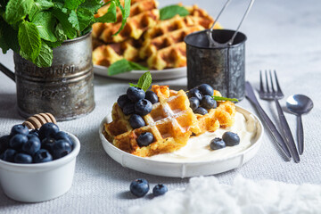 Belgian waffles with sour cream and blueberries in a plate