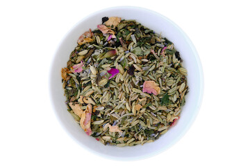 Dried tea herbs (lavender blossoms, fennel seeds, peppermint leaves, melissa leaves, thyme, sage) and rose petals in a white bowl, isolated on a white background