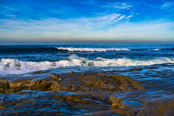 2023-12-31 SEVERAL WAVES COMING ASHORE NEAR LA JOLLA WITH ROCKS IN THE FOREGROUND AND A NICE CLOUDY SKY NEAR SAN DIEGO CALIFORNIA
