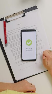 Vertical Screen: Woman working from home paying online from phone. Happy costumer accepted payment online contactless.