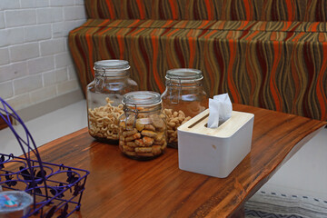 three jars of pastries on the table, next to a tissue box
