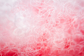 Fototapeta premium Extreme macro of polyester stable fiber on red background. Selective focus, shallow depth of field. Abstract dreamy background