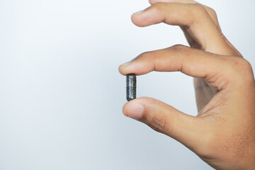 a man holding Nigella sativa oil in a pill (black cumin, also known as habbatussauda).