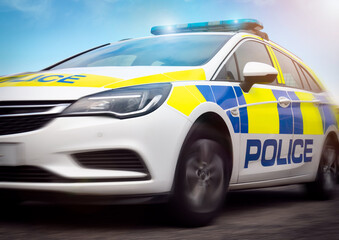 Police car - scene of emergency services' police force vehicle in action featuring a cop car with lights and siren on, travelling at high speed in response to an incident.