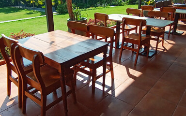 Dining table with chair made of wood on the outside surround with garden green field