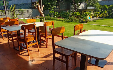 Dining table with chair made of wood on the outside surround with garden green field