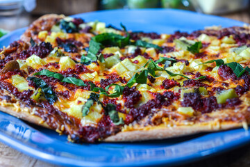 Pizza de chorizo de soya, piña, kiwi, espinaca