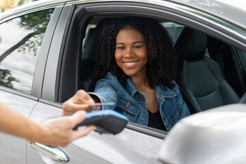 African American woman  rents a car and pays the rent with a credit card. Contactless payment,...