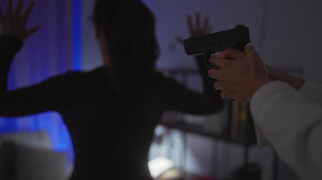A tense scene with a woman aiming a handgun at another woman indoors, possibly depicting crime, threat, or law enforcement.