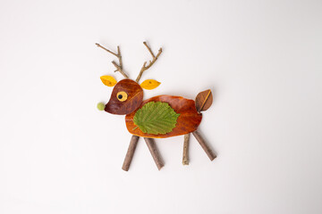 Creative representation of deer made from natural materials against plain background. Body crafted...