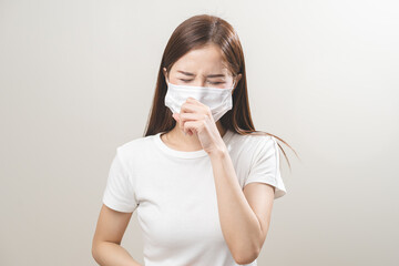 Unhealthy sickness, unwell asian young woman wearing mask coughing, have sore throat, suffering symptom cough feeling bad and healthcare of air pollution and dust, PM2.5 isolated white background.