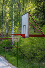 New basketball board with basket. Close up basketball hoop, board or basket. Close-up of net of basketball hoop in sunny day. Basketball rim in orange color bottom view on a white background.