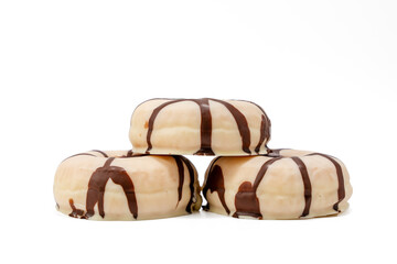 Three donuts stacked on top of each other with chocolate drizzle. Concept of indulgence and sweetness