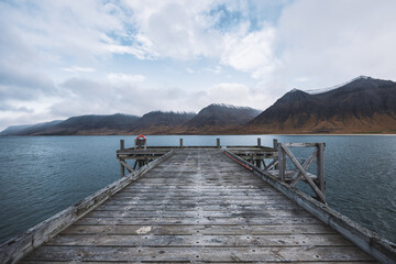 Obraz premium View from a pier in an Icelandic fjord overlooking the mountains on a sunny day.