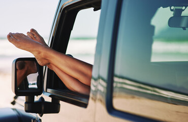Relax, car and woman feet in window for road trip, travel adventure and summer vacation by beach. Female person, barefoot and legs out of motor for holiday drive, peace and stop by ocean for rest