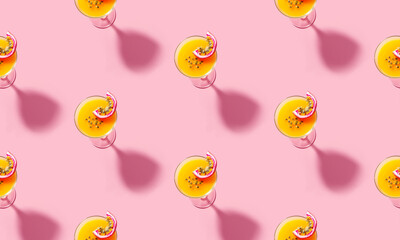 Seamless pattern of martini cocktails with sliced passion fruit bold shadow at the pink background. Cocktail pattern for concept design. Minimal style background. Top view