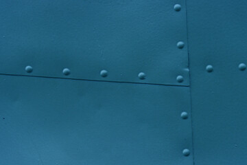 Blue Metallic surface with rivets.