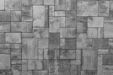 Fototapeta premium Road surface is made of paving stones. The texture is made of large gray cement bricks.