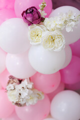Delicate pink organza photo zone with a neon sign, balloons, a butterfly and flowers.