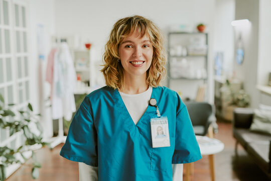 Portrait of blonde nurse looking at camera directly and smiling widely showing her teeth