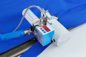 Fabric cutting machine with built-in tape measure. Sewing workshop.