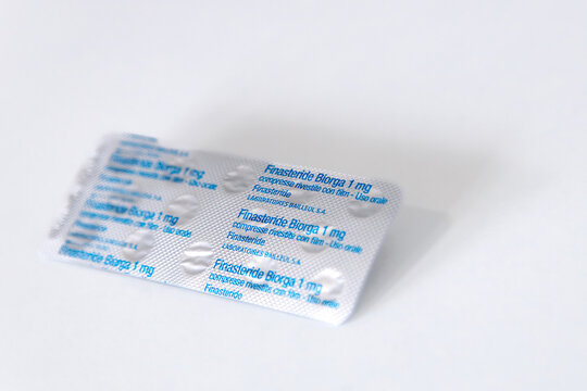 A blister pack of 1mg finasteride tablets against a white background