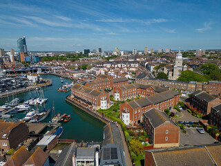 Moored sailing boats in Portsmouth marina with historic cathedral. Aerial city view in the summer. Waterfront residential buildings.