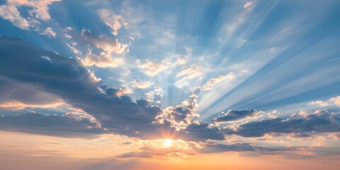 Obraz premium Sun sets behind vibrant clouds casting dramatic rays in the sky. Concept Nature, Sunset, Clouds, Sky, Landscape