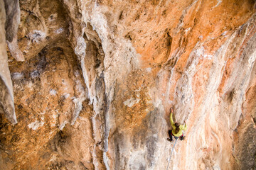 A rock climber climbs to the top of the mountains along a difficult route.