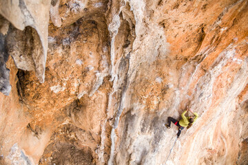 A rock climber climbs to the top of the mountains along a difficult route.