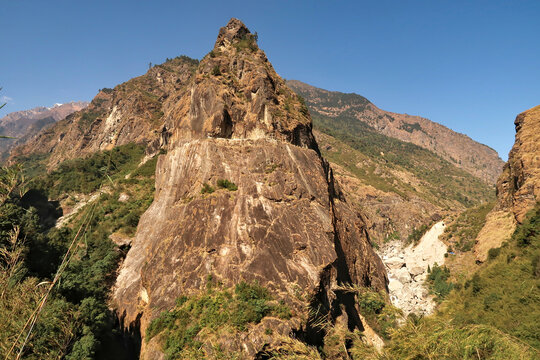 View from the trail onto a giant rock, boulder, that has a part of the road from Besisahar, Bhulbhule to Chame, Manang carved into it, close to Tal village, Annapurna Circuit Trek, Nepal