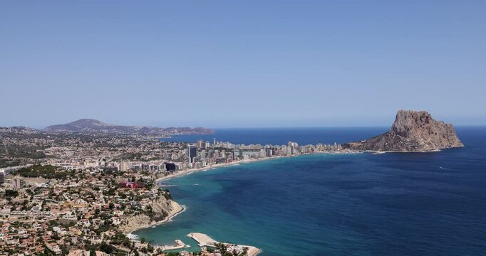 Footage of the beautiful coastal town of Calp on Spain&rsquo;s Mediterranean coast showing an aerial drone view of the coastal front from above on a sunny day in the summer time