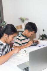 Asian elementary school children studying mathematics in class intently.