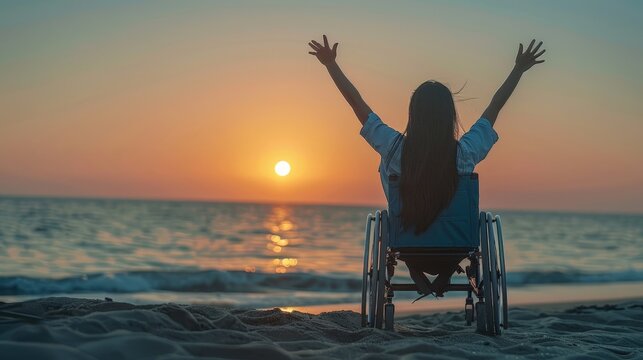 Woman in wheelchair raising arms in celebration on the beach at sunset. Embracing freedom and joy. - Powered by Adobe