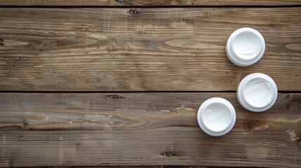 Top view of white cosmetic containers on wooden background with empty space