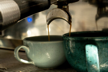 The coffee machine prepares fresh coffee and fills two cups at the same time. Close-up. The process of professional coffee preparation.