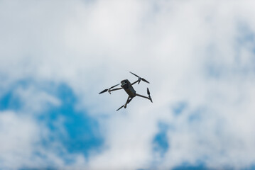 controlled modern drone flying in blue sky. Real photo.