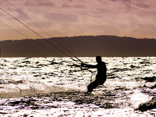 Kite surfer riding waves. Kiteboarding sport.