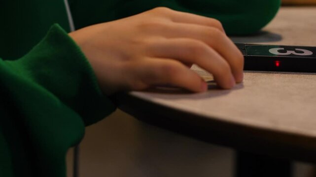 order readiness pager in a fast food restaurant on the table and a child's hand of a client waiting for the order to be prepared. fast food restaurant preparing the order