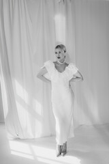 Black and white photo of an elegant woman with blonde bob haircut and red lipstick posing...